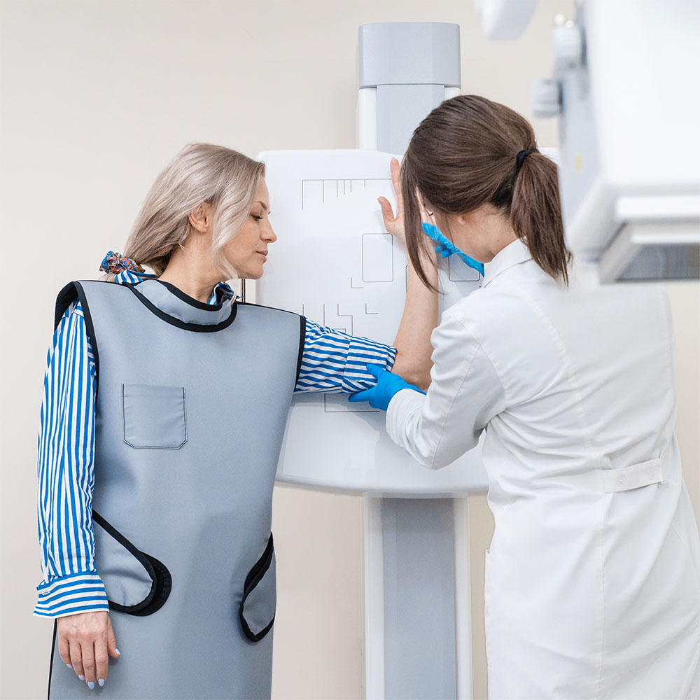 Woman getting scanned on imaging machine with doctor